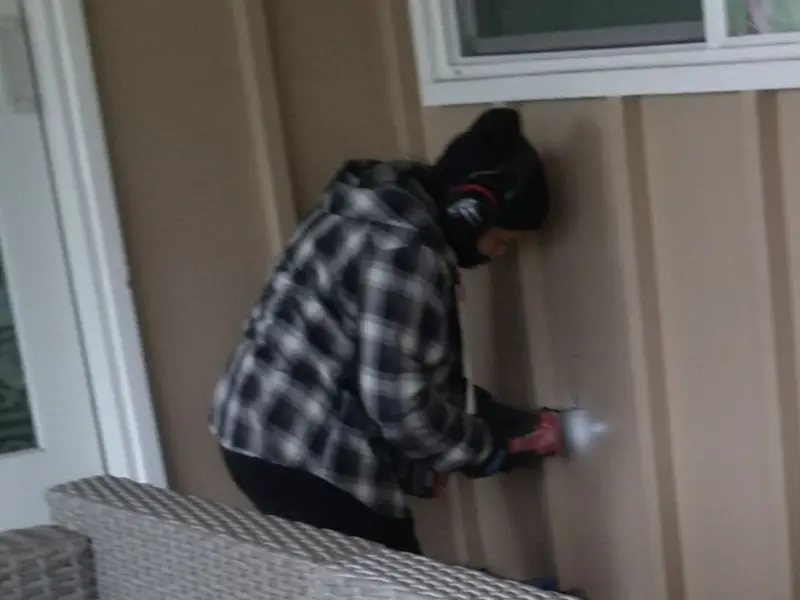 Professional electrician installing an exterior outlet in Rollin